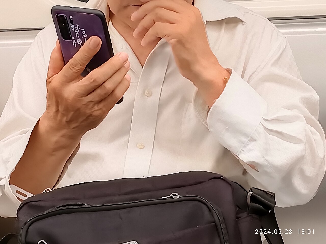 SZ Shenzhen man in white shirt long sleeve May 2024 R12S human hand holding smartphone.jpg